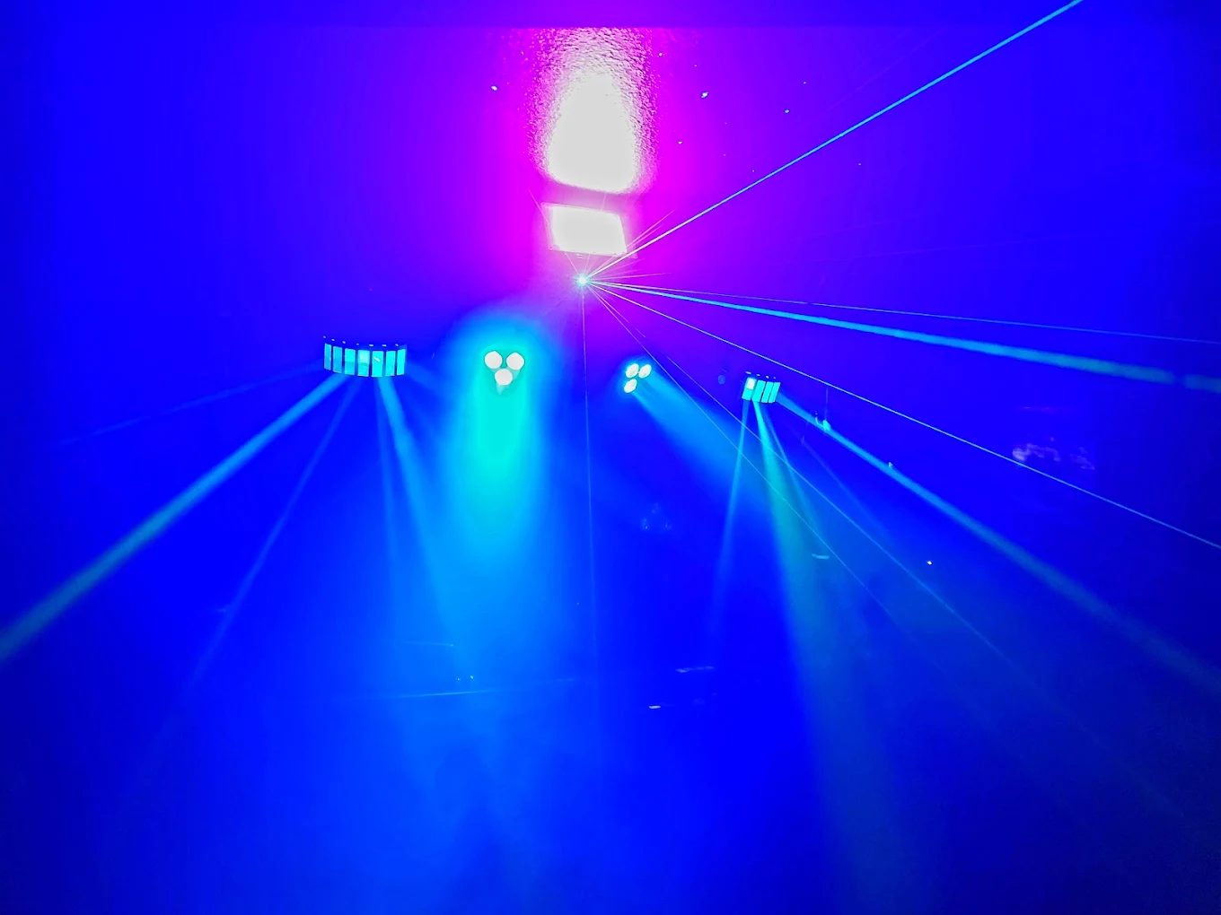 Blue and violet moving-head lights and lasers over a dance floor